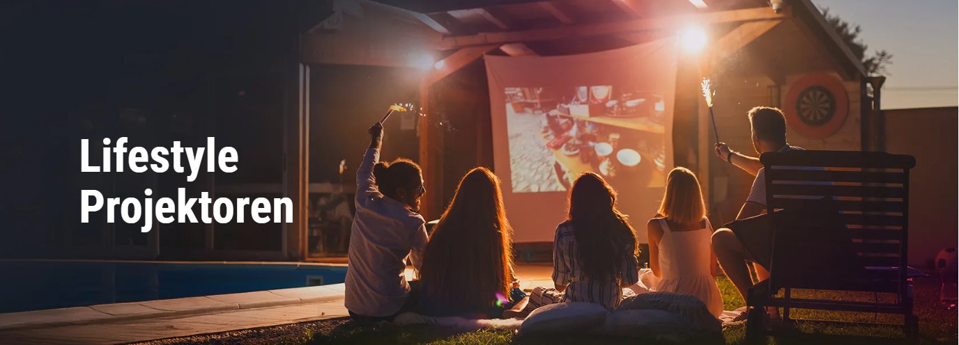 Gruppe sitzt bei einem nächtlichen Outdoor-Kinoabend vor einer Leinwand, Projektor im Einsatz